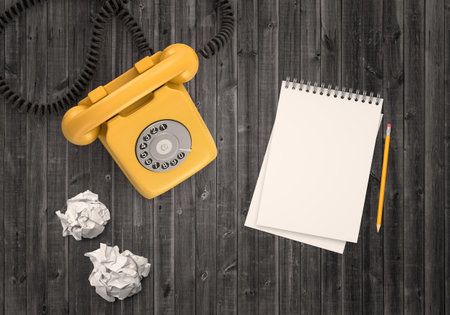 Retro yellow phone and notepad on deskの写真素材