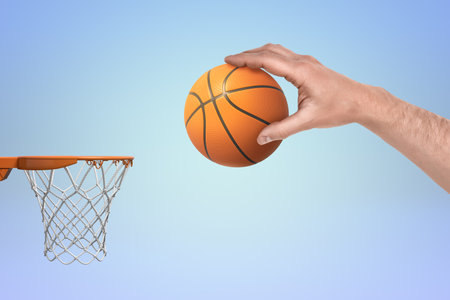 Hand scoring a basketball in a hoopの写真素材