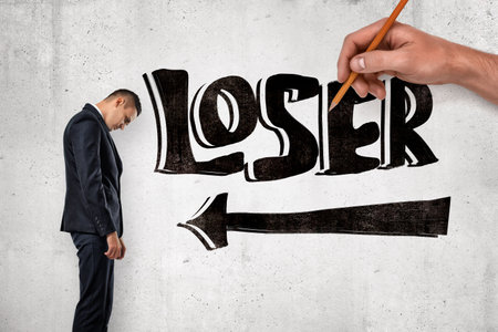 Man facing LOSER label with pencil arrowの写真素材