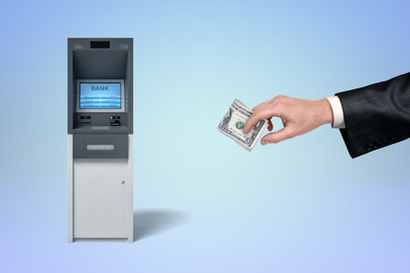 Hand withdrawing cash from ATM machineの写真素材