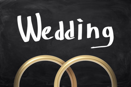 Wedding rings on a chalkboard backgroundの写真素材
