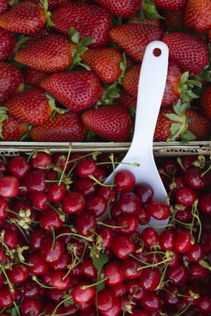 Strawberries and cherries in baskets at the market 