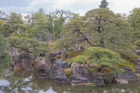 The castle gardens feature landscaped ponds, stone arrangements, and cherry trees, blending tsukiyama and karesansui styles to create seasonal beauty and meditative tranquility.の写真素材