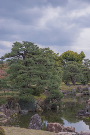 The castle gardens feature landscaped ponds, stone arrangements, and cherry trees, blending tsukiyama and karesansui styles to create seasonal beauty and meditative tranquility.の写真素材