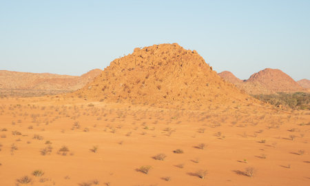 The Namibian desert is home to scattered brown stones and rugged rock formations shaped by natural processes over millennia.の写真素材