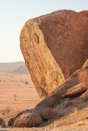 The Namibian desert is home to scattered brown stones and rugged rock formations shaped by natural processes over millennia.の写真素材