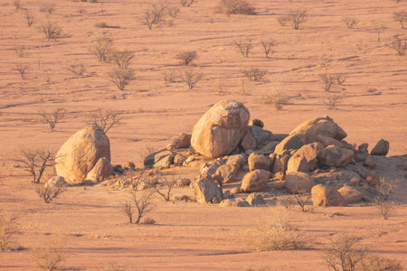 The Namibian desert is home to scattered brown stones and rugged rock formations shaped by natural processes over millennia.の写真素材