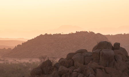 The Namibian desert is home to scattered brown stones and rugged rock formations shaped by natural processes over millennia.の写真素材