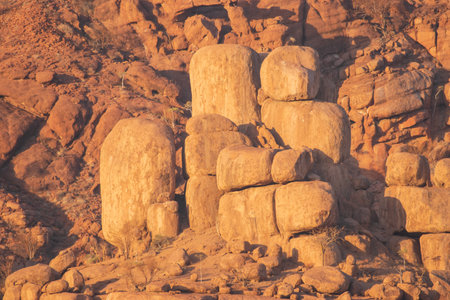 The Namibian desert is home to scattered brown stones and rugged rock formations shaped by natural processes over millennia.の写真素材
