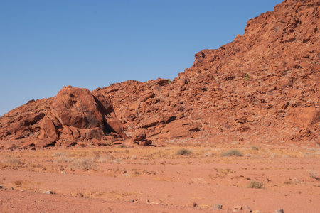 The Namibian desert is home to scattered brown stones and rugged rock formations shaped by natural processes over millennia.の写真素材