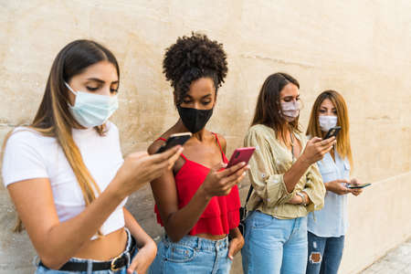 Group only young women multiracial with face mask using smartphone - Group only young girls...