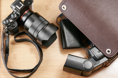 Shot of a mirror-less camera and flash unit on a wooden surfaceの写真素材