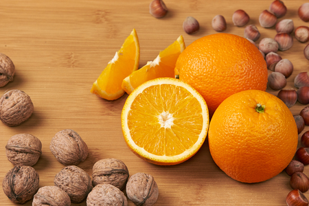 Shot of fresh oranges and nuts on a wooden surfaceの写真素材