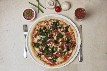 Shot of a pizza a white dish on a marble tableの写真素材