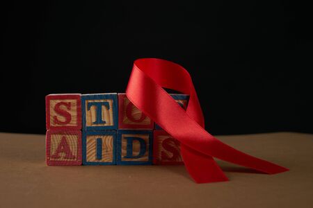 Stop AIDS on Cubes with letters and red awareness ribbon on a tableの写真素材