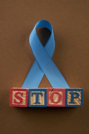 Prostate cancer awareness blue ribbon and cubes with letters. Stop word. Men healthcare conceptの写真素材