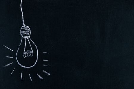 Idea concept, Light bulb lamp drawn on blackboard background with copy spaceの写真素材