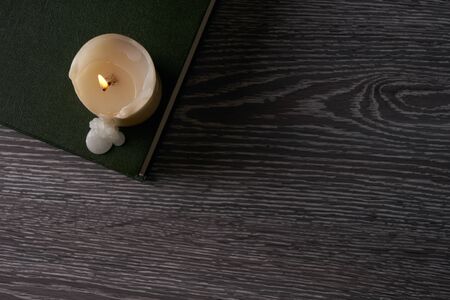 Top view of book and candle on wooden table. Education, knowledge concept with copy spaceの写真素材