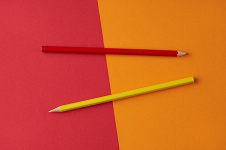 Colorful image of two pencils on red and orange background.  Office, school supplyの写真素材