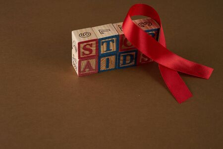 Stop AIDS on Cubes with letters and red awareness ribbon on a tableの写真素材