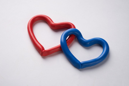 Red and blue plasticine heart. Isolated on white backgroundの写真素材