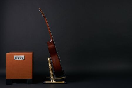 Combo amplifier for guitar with classical acoustic guitar on the black background with copy spaceの写真素材