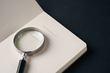 Close up of magnifying glass on notebookの写真素材
