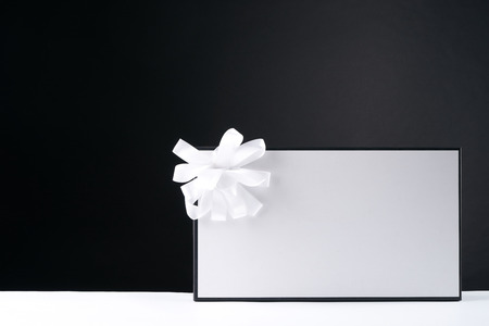 White gift box with ribbon on the black background.Copy space.の写真素材