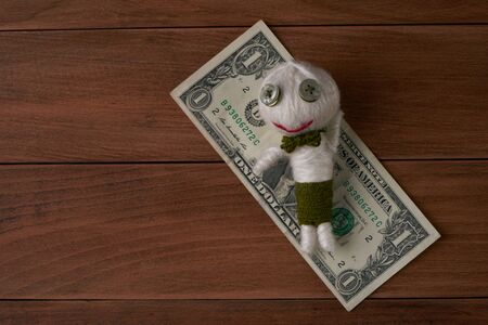 Cute Little Voodoo Doll with money on wooden background.Top viewの写真素材