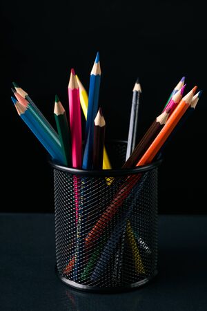 Colorful crayons, pencils in black pencil box against dark backgroundの写真素材