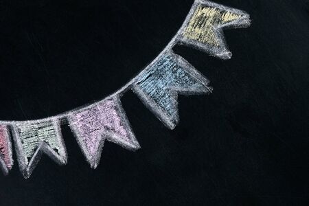 Colored flags on a rope drawn on blackboard, chalk boardの写真素材