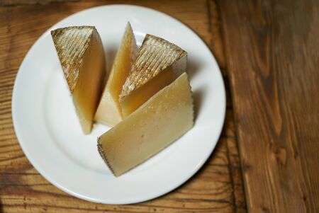 White plate of cheese on old,vintage,wooden background.の写真素材