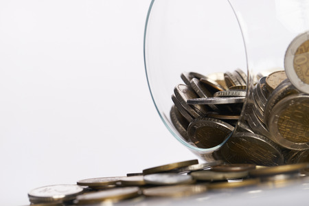 Gold coins in a piggy bank vase isolated on white.Copy space