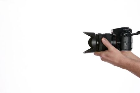Camera in hand. Close-up of hand holding camera while isolated on whiteの写真素材