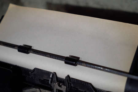 Close-up of an old black vintage typewriter and white typewriter paper with copy space. Good for any author or writer with creative dreams of journalism.の写真素材