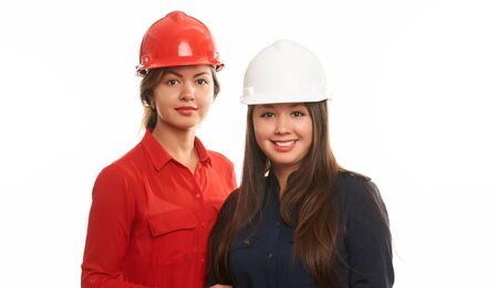 Portrait of two female engineers, construction workers in protective hard hat or helmet isolated on white. Safety conceptの写真素材
