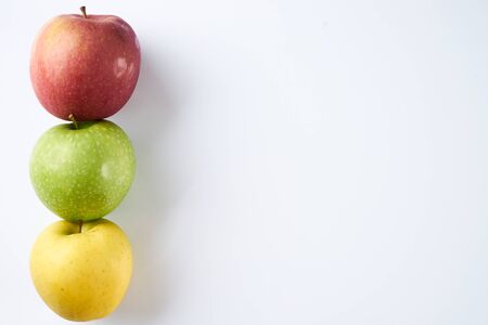 Three apples different colors looks like traffic light. Red, green and yellow apples isolated on white background with copy space. Healthy food and detox concept.の写真素材