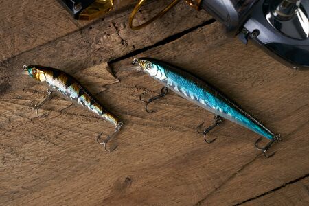 Fishing gear - fishing spinning, hooks, fishnet and lures on old wooden board.