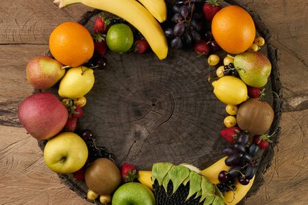 Top view of a huge group of fresh vegetables and fruit on wooden background with copy space. Vegetables VS Fruit - High quality studio shotの写真素材