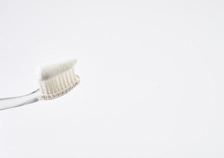 Clear new toothbrush with white mint toothpaste isolated on white background with copy space. Dental hygiene and care.の写真素材