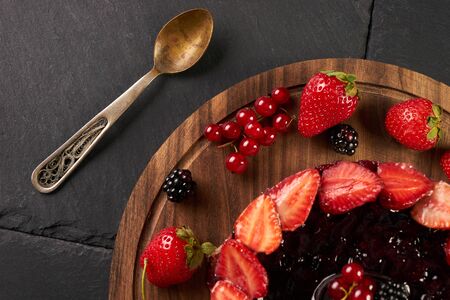 Close-up of a mix berries cake with Strawberry Blackberry Red Currant on wooden board. Top viewの写真素材