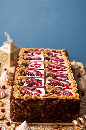 Delicious Chocolate cake with banana, walnut, meringue and custard whipped cream on wooden table with christmas decorationsの写真素材