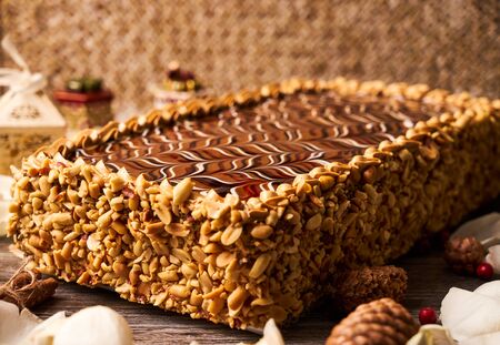 Peanut cake with chocolate and whipped custard cream on wooden table background with christmas decorations, sweet dessert foodの写真素材