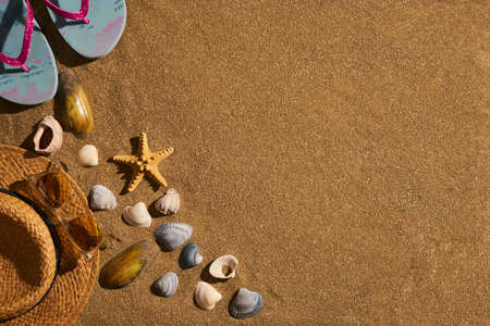 Summer accessories straw hat, glasses, shoes at the beach sand, Travel concept, Vacation time. Summer background with copy space.の写真素材