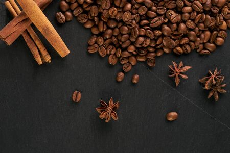 Aroma coffee ingredients. arabica coffee beans, anise and cinnamon on dark stone background.の写真素材