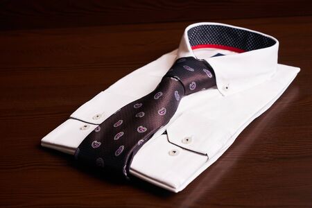 New light man's shirt with tie on wooden background, close-up mans fashionの写真素材
