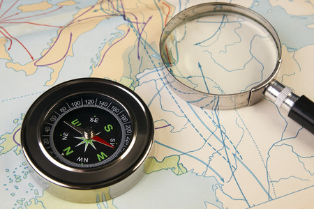 Compass and magnifying glass on map