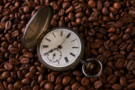 Old vintage pocket watch in roasted coffee beansの写真素材
