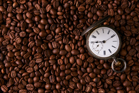 Old vintage pocket watch in roasted coffee beansの写真素材