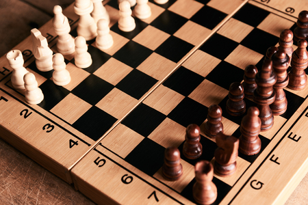 Chess pieces and chessboard on a wooden table